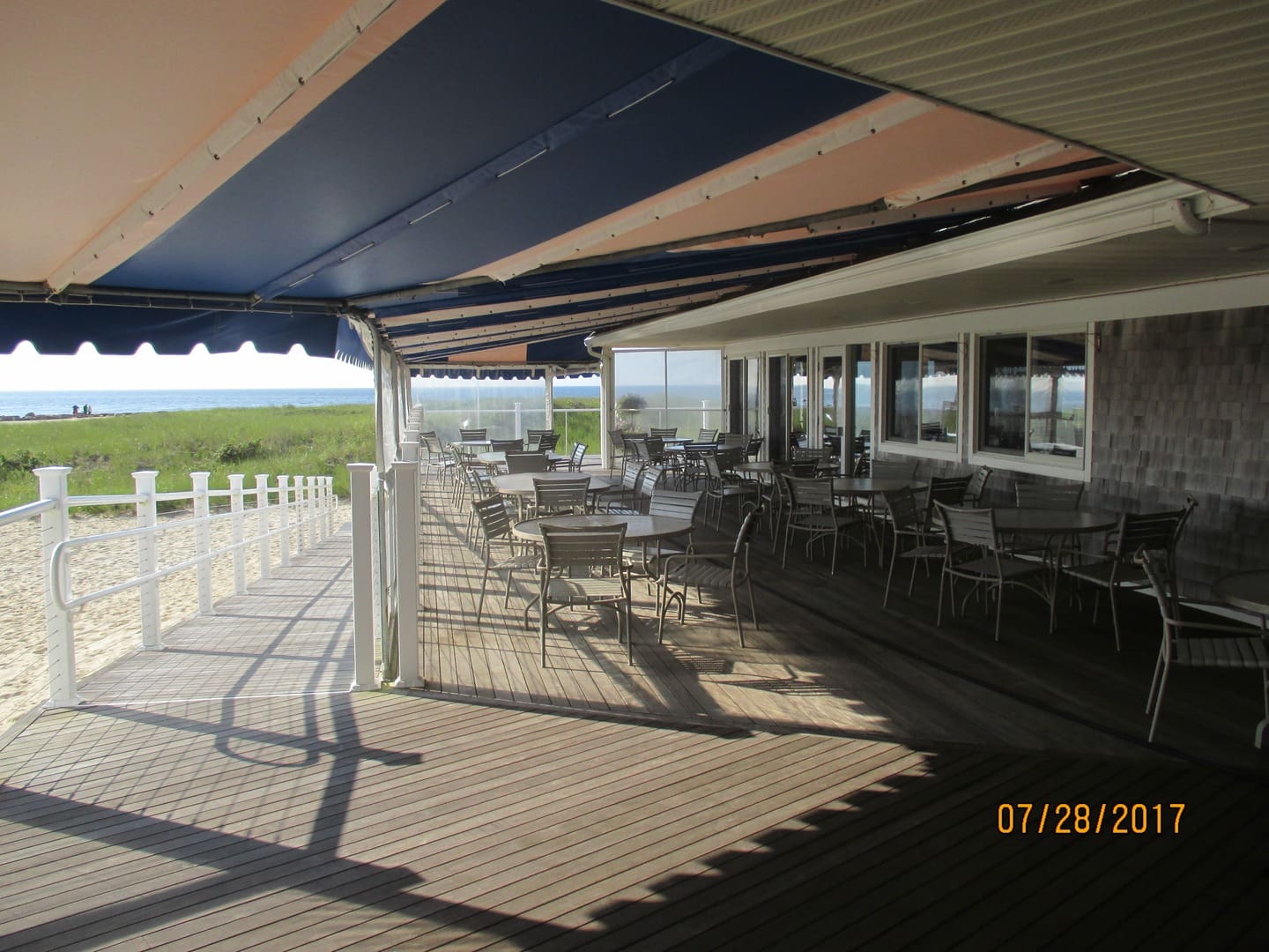 A patio with tables and chairs on the deck.