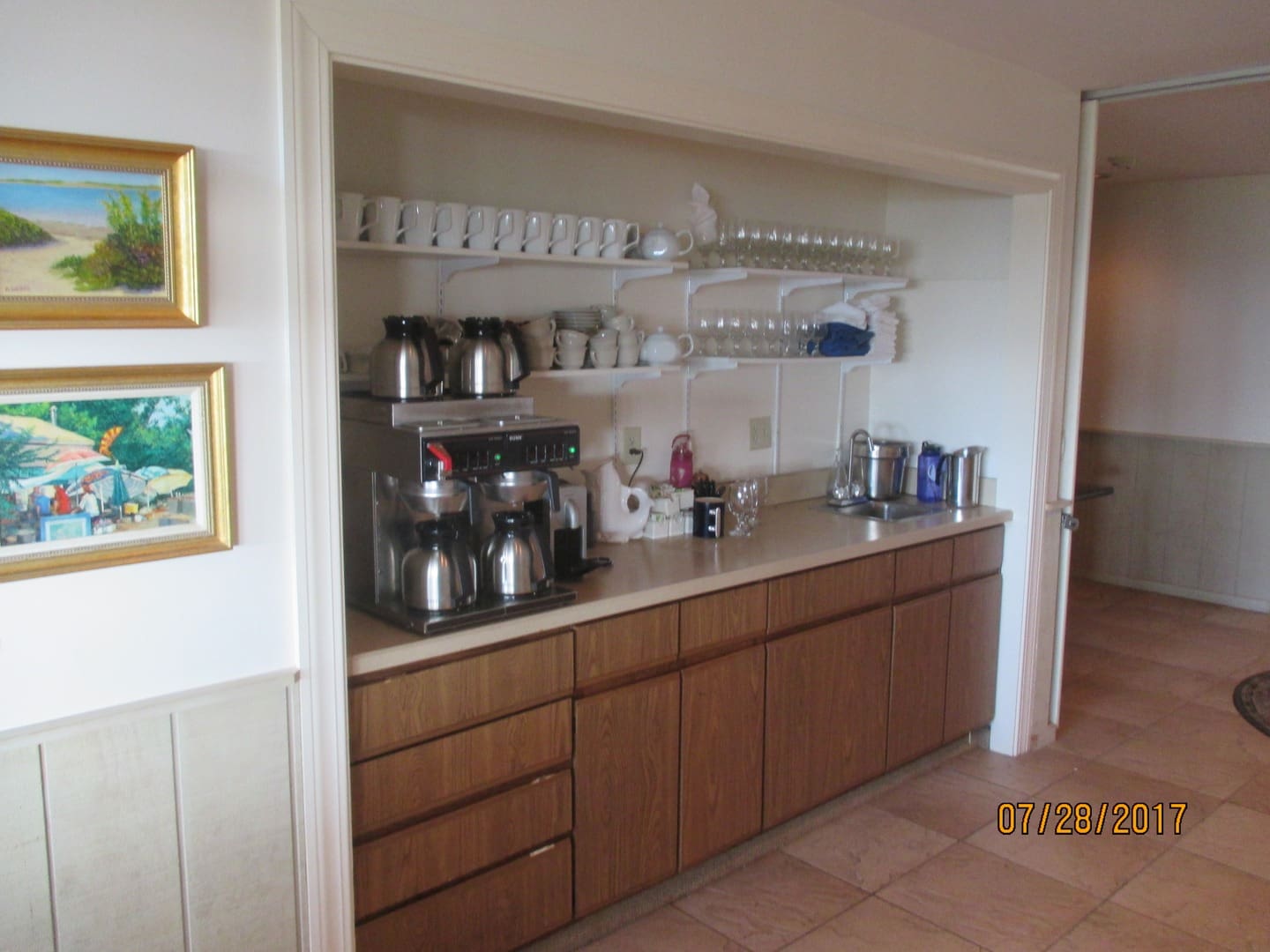 A kitchen with many pots and pans on the counter.