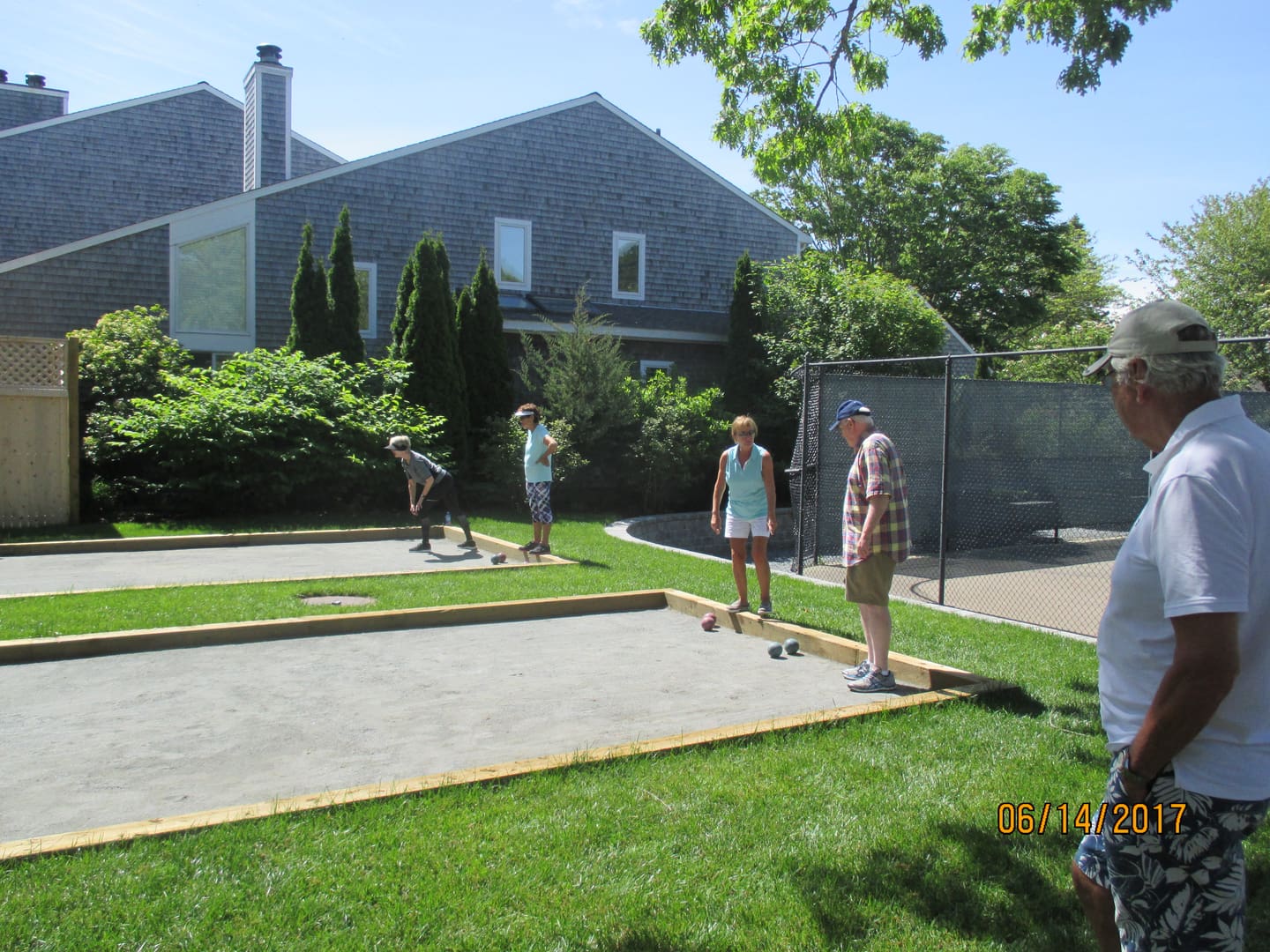 A group of people playing with skateboards in the yard.