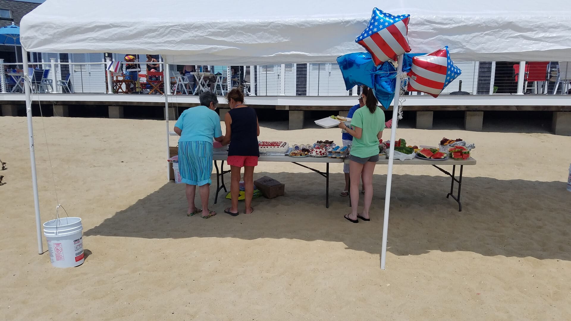 A group of people standing around an outdoor tent.