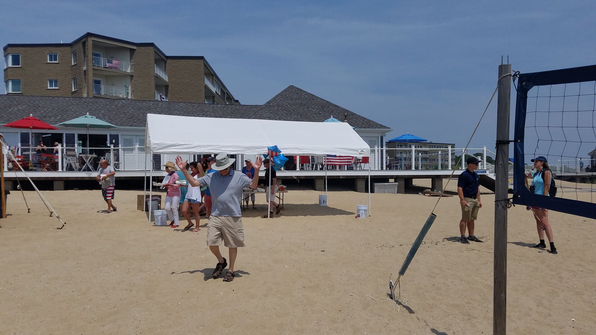 A group of people standing on top of a sandy beach.