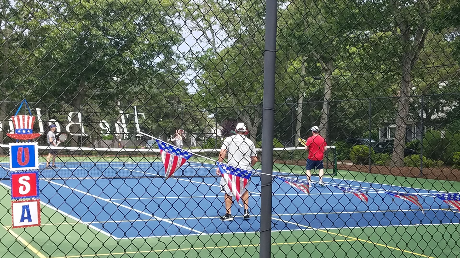 A group of people playing tennis on the court