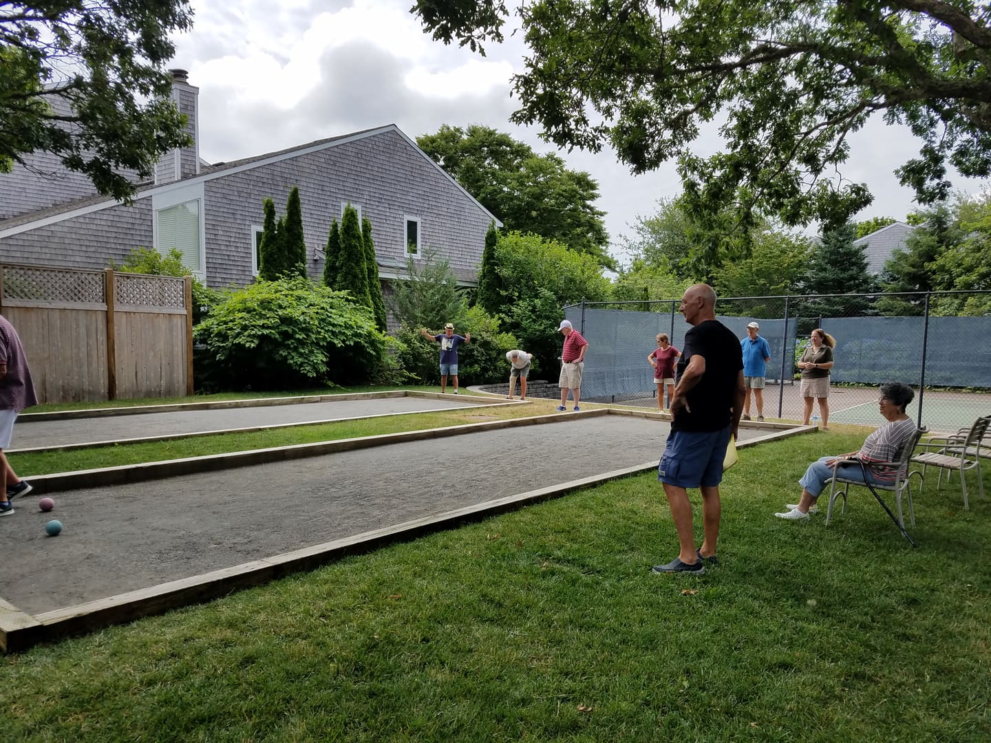 A man standing on the grass near some people.