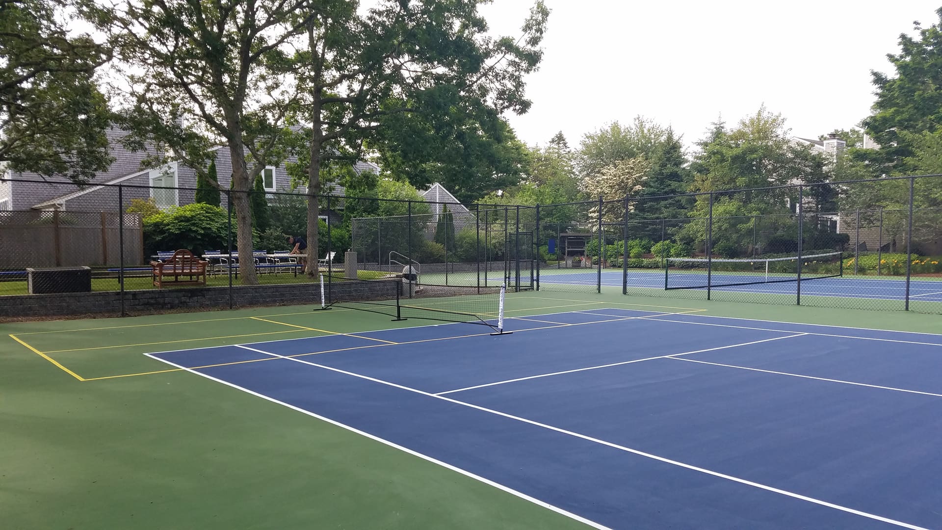 A tennis court with trees in the background.