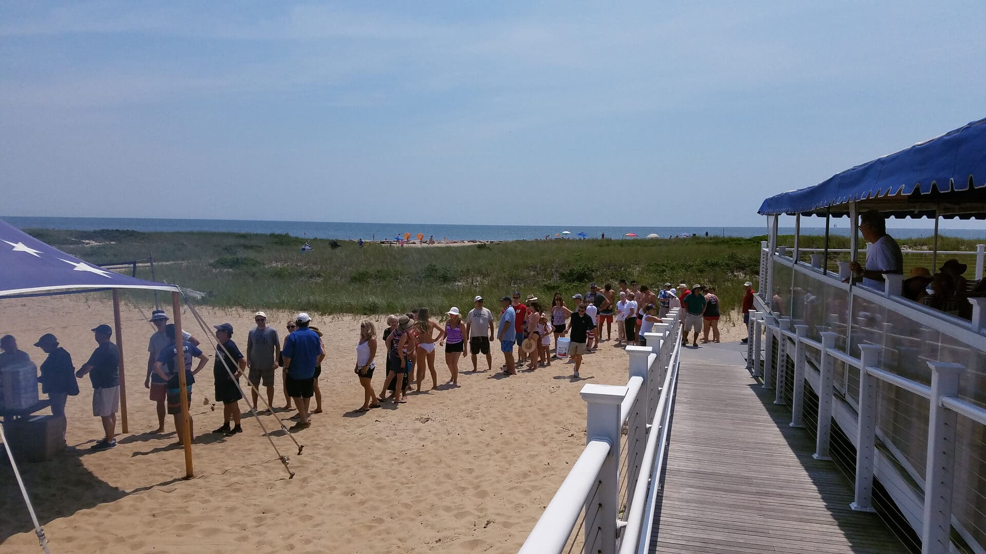 A group of people standing on top of a sandy beach.