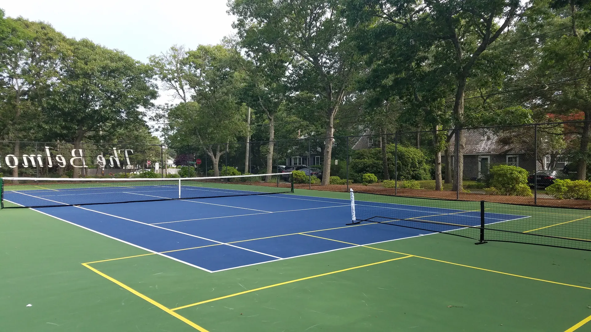 A tennis court with trees in the background.
