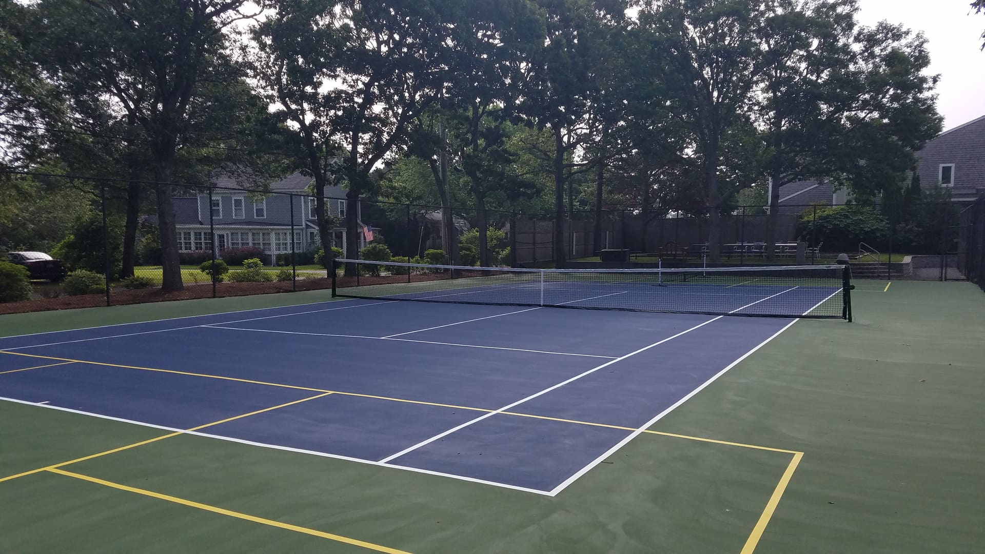 A tennis court with trees in the background.