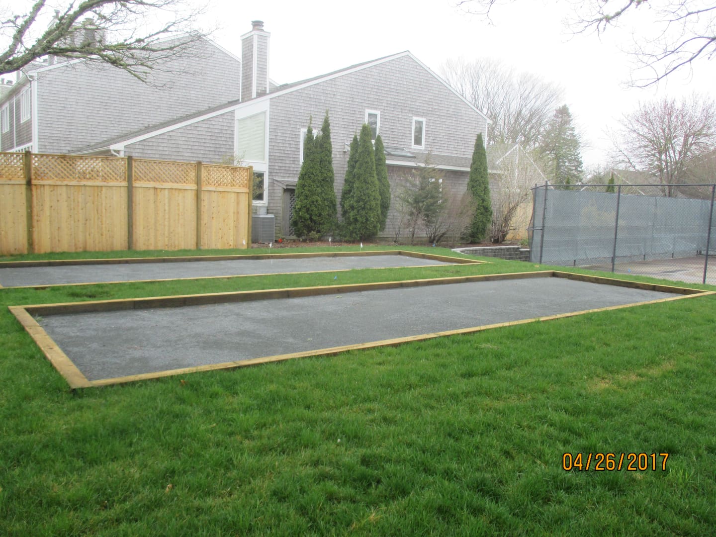A backyard with grass and trees in the background.