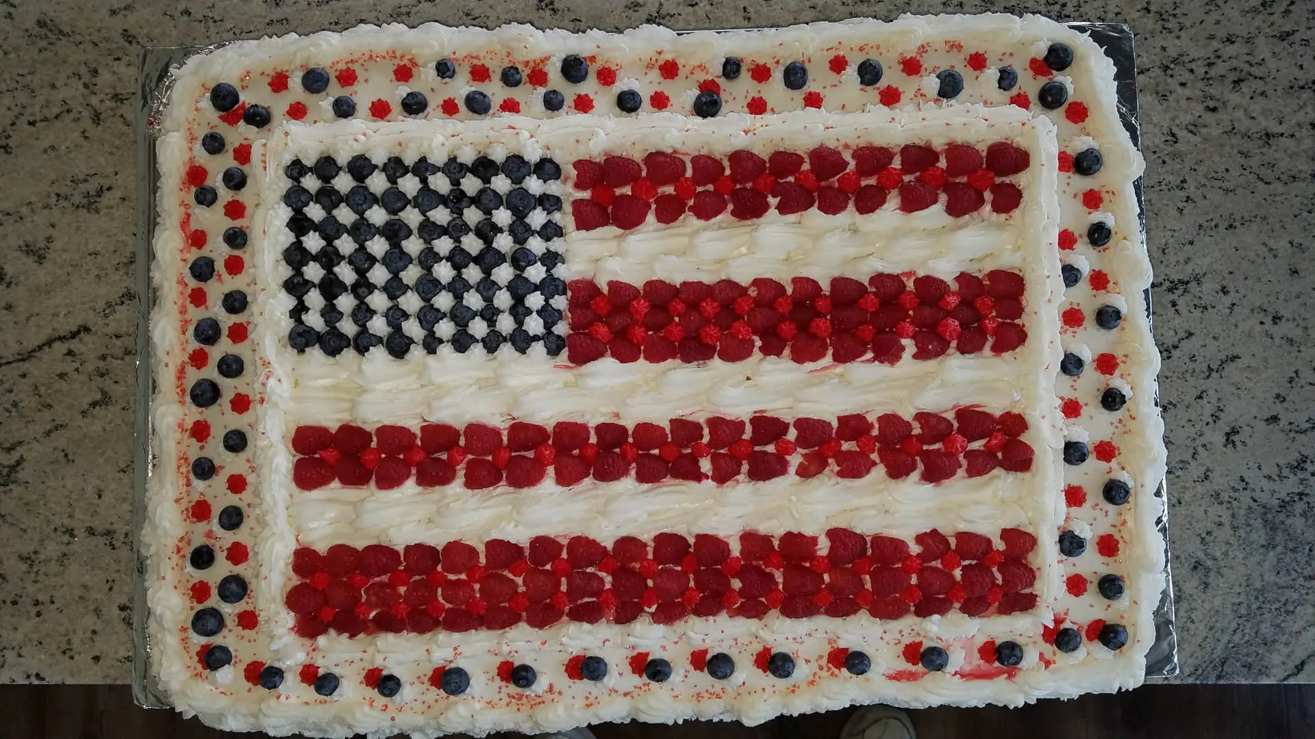 A cake with red, white and blue frosting in the shape of an american flag.