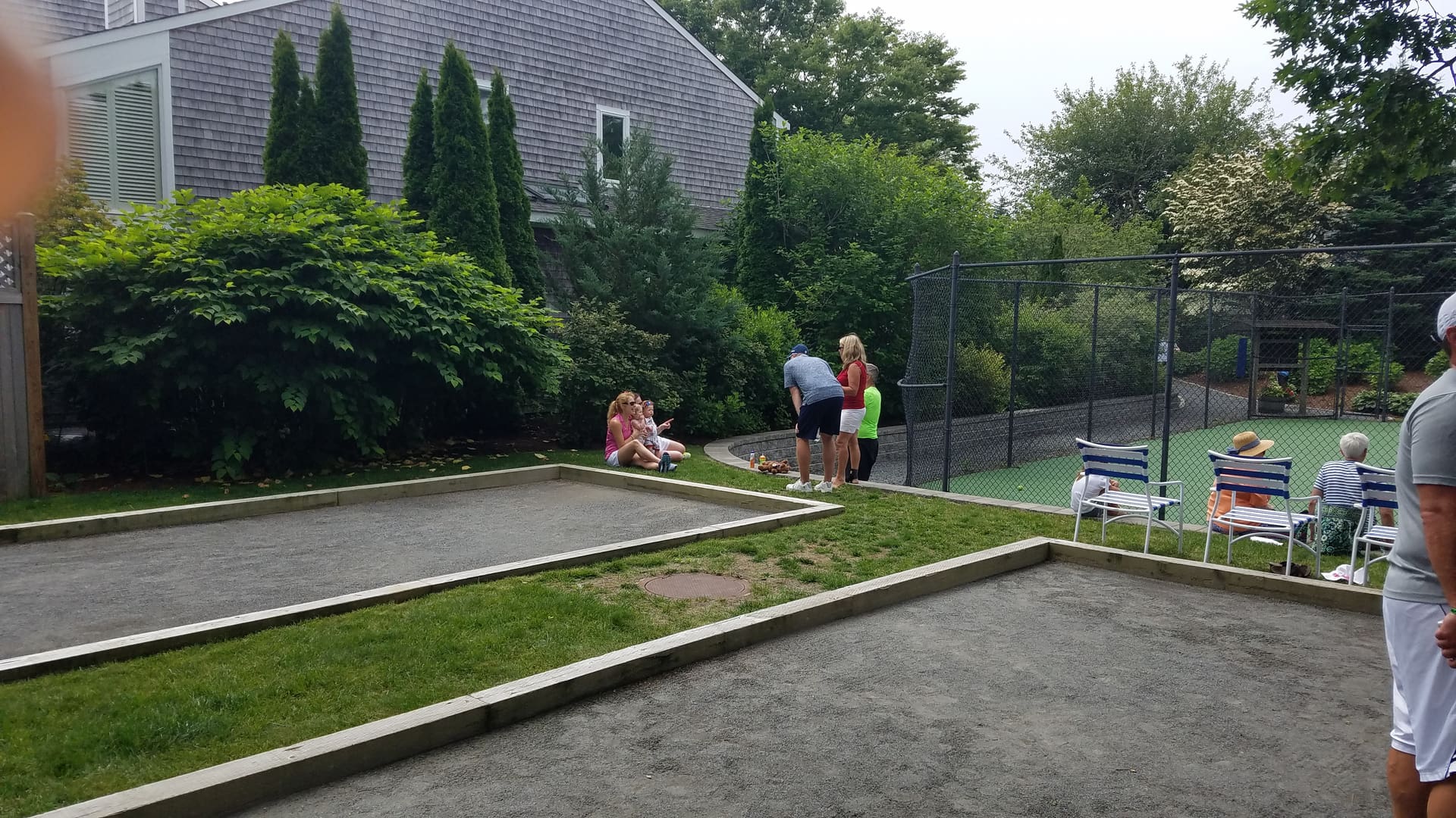 A group of people standing around in the yard.