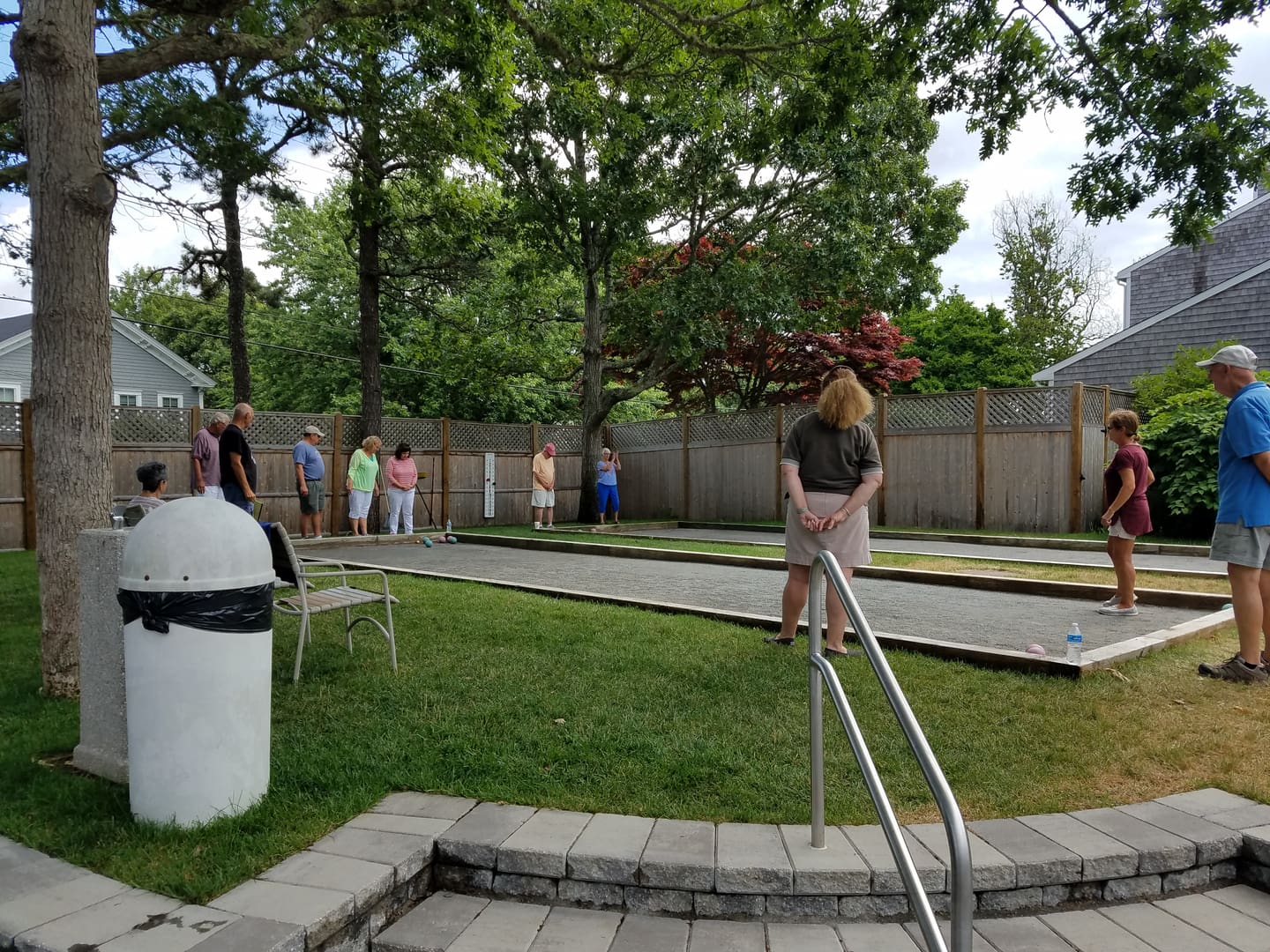 A group of people standing around in the grass.