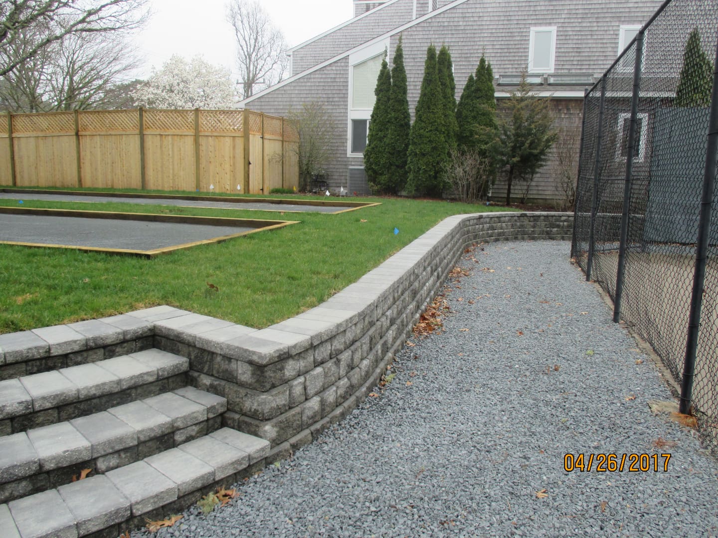 A backyard with steps and grass on the ground.